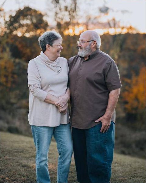 Casal de idosos sorrindo ao ar livre